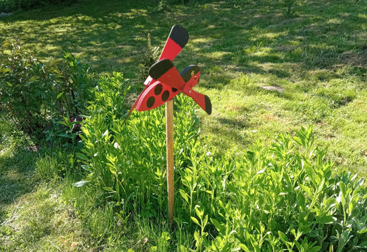 Wiatrak ogrodowy w kształcie biedronki, 47 cm – urocza dekoracja ogrodowa z drewna, która jednocześnie skutecznie odstrasza ptaki.