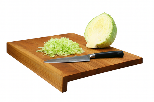 Drewniana deska kuchenna z rantem z czereśniowego drewna, na której leży ćwiartka główki kapusty, pokrojona kapusta i nóż kuchenny ze stalowym ostrzem — produkt Chłopcy z Rancza.