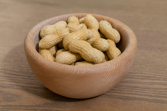 Drewniana miska z parzonego buka o średnicy 10 cm, wypełniona orzeszkami ziemnymi, ustawiona na stole – Chłopcy z Rancza.