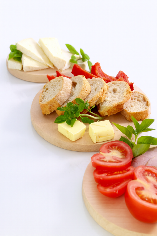 Zestaw drewnianych desek z pieczywem, masłem, pomidorami i serem – idealne deski kuchenne z drewna bukowego.