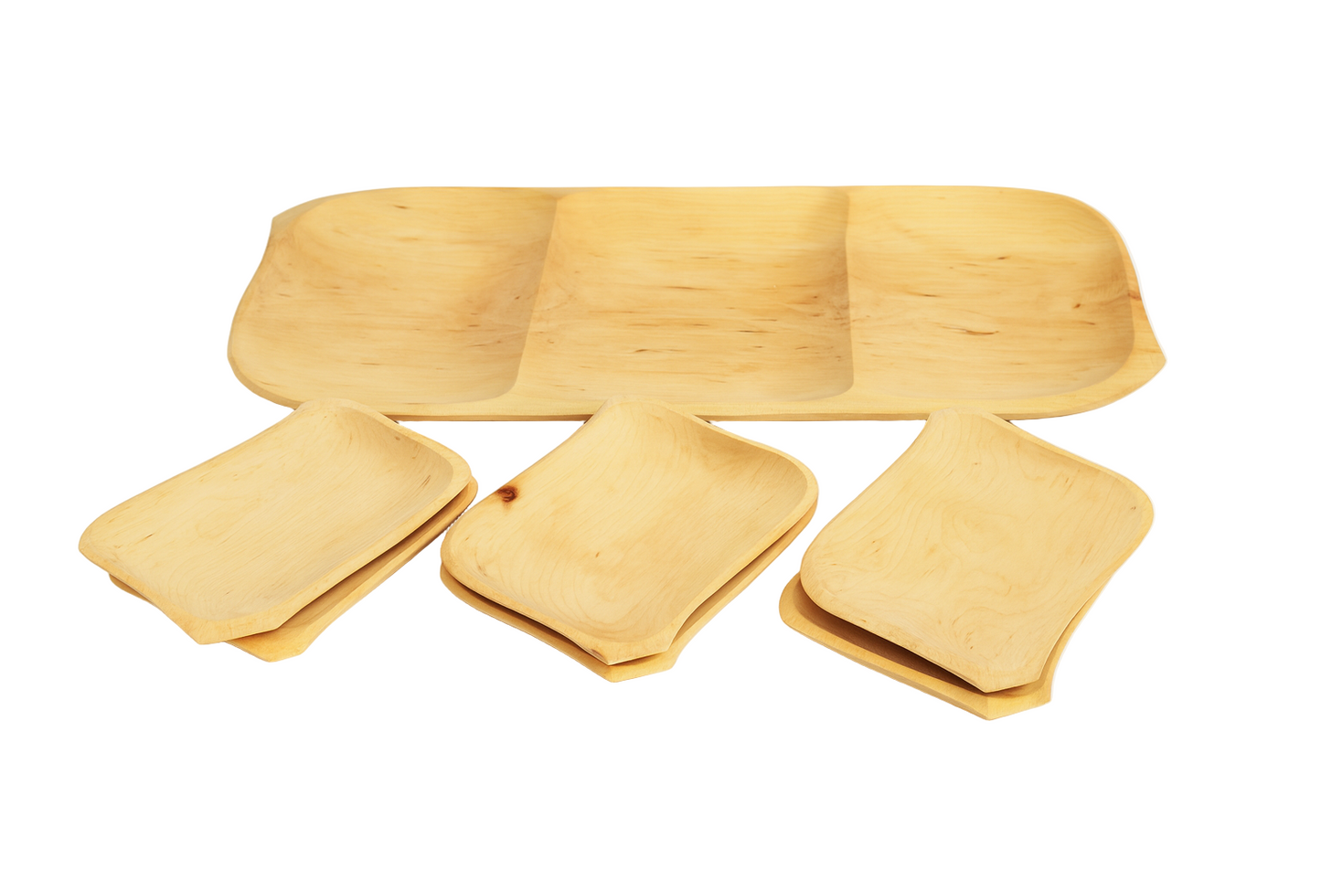 Zestaw drewnianych talerzy i misek na białym tle — w tle duża taca z trzema przegrodami, z przodu cztery mniejsze prostokątne miseczki ułożone po dwie w stosy. Naturalny kolor drewna, widoczne słoje i delikatne przebarwienia,